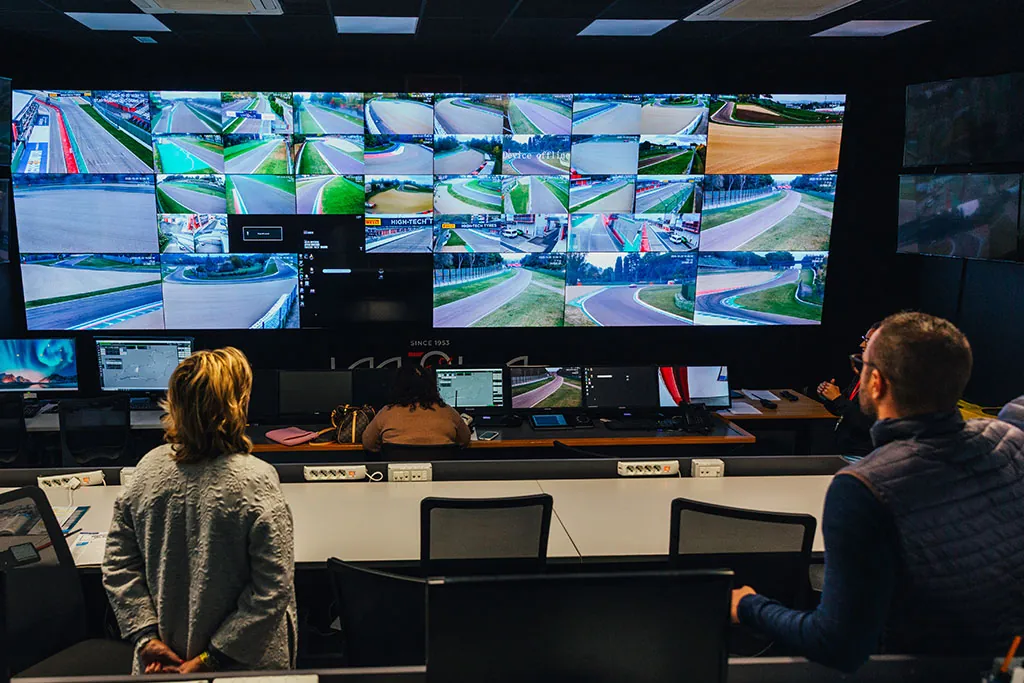 Sala di controllo del circuito con parete di monitor sulle curve della pista
